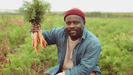 Portrait-of-African-American-Farmer-with-Bunch-of-Freshly-Picked-Carrots